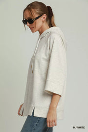 Side view of the H. WHITE Umgee 3/4 Sleeve Tunic Top with Graphic Hoodie, styled with polished boutique styling for day-to-night outfits, made for women who want easy layering.