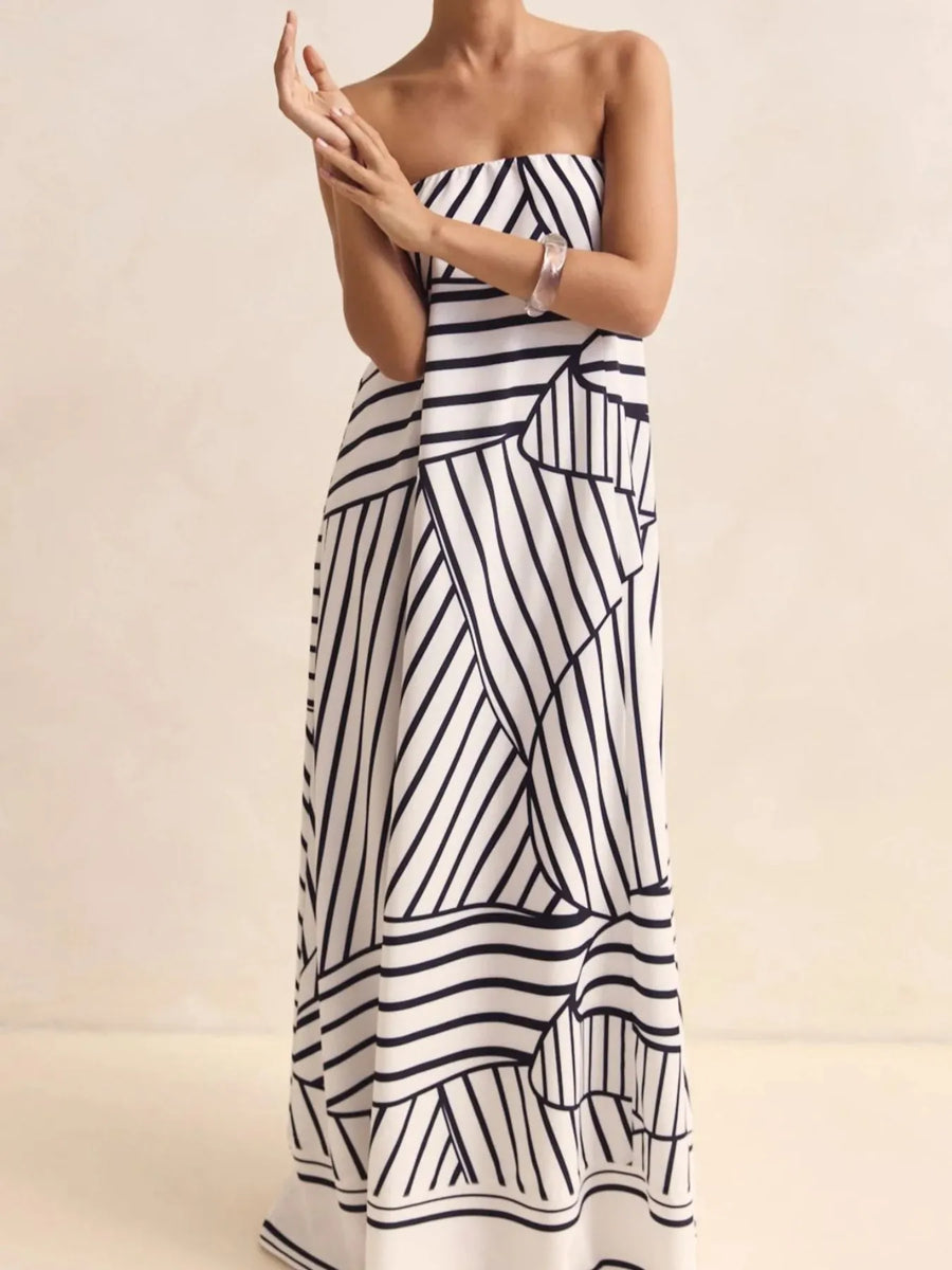 Front view of the Black Stripes Smocked Printed Tube Maxi Dress, styled with feminine boutique styling for dinners, travel, and events, made for women who want elegant styling.