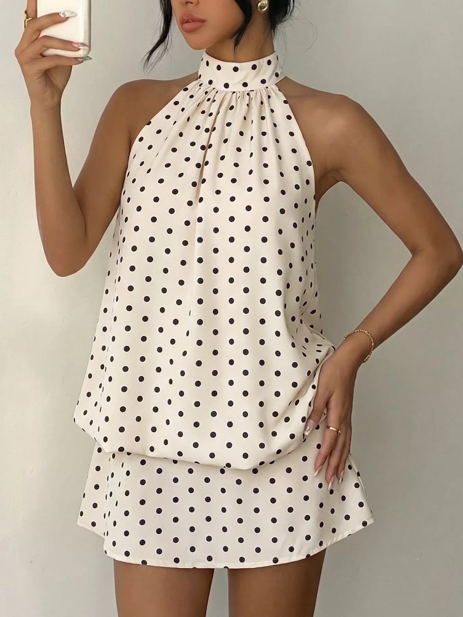 Front view of the Apricot Polka Dot Halter Neck Mini Dress, styled with feminine boutique styling for dinners, travel, and events, made for women who want elegant styling.