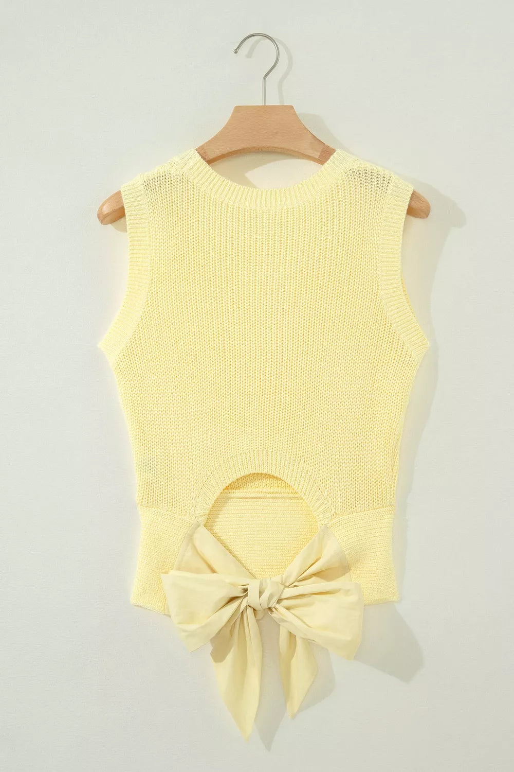 Styled outfit view of the Light Yellow Solid Color Cropped Knit Knot Back Cutout Sweater Tank, styled with polished boutique styling for day-to-night outfits, made for women who want easy layering.